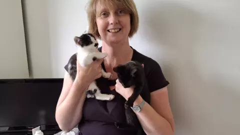 Blue cross pet fosterer Louisa Tongue holds her two foster kittens